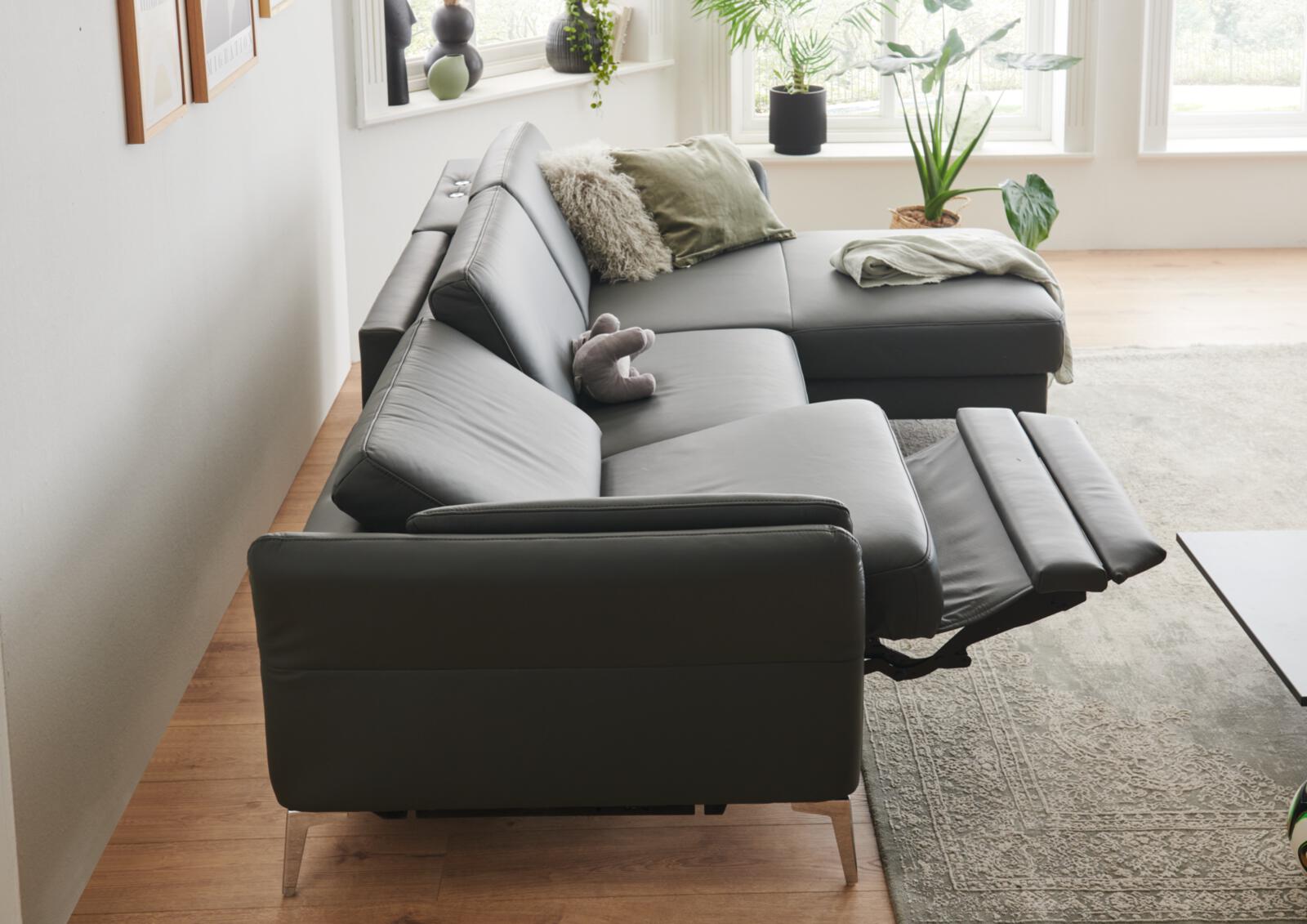 Graues Ledersofa mit ausgefahrener Wall Away Funktion